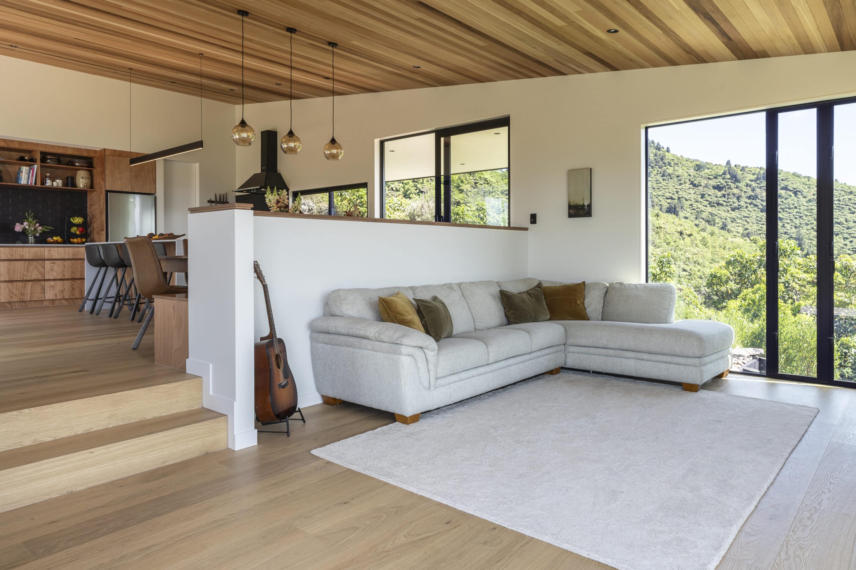 White oak hardwood flooring in open plan living dining with timber ceilings and a view